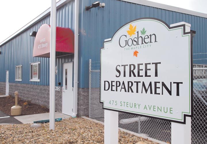 Sign that reads "Street Department, 475 Steury Avenue" with blue building in the background.